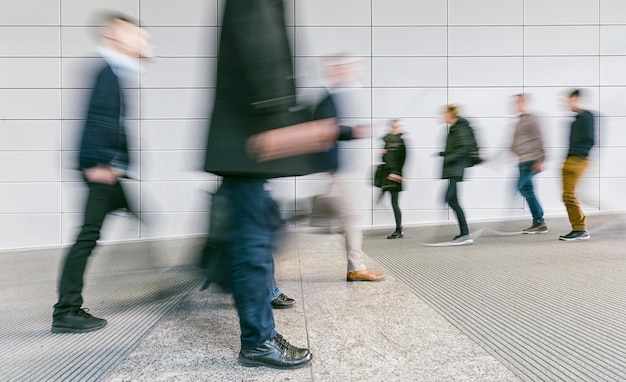 Foto multitud de personas borrosas caminando en un corredor futurista