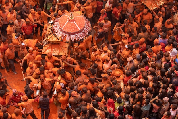 Una multitud de personas está cubierta con ropa de color naranja y la palabra "holi" en la parte superior del objeto.