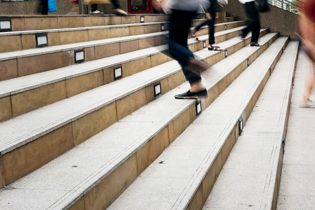 Multitud de personas en movimiento borroso subiendo y bajando la escalera