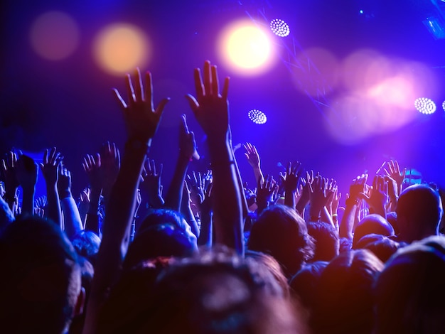 Foto una multitud de personas en la pista de baile con las manos levantadas y luces de discoteca.