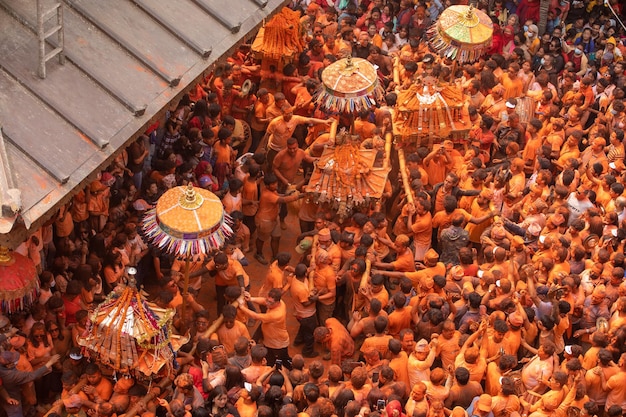 Una multitud de personas se reúne en naranja y amarillo con la palabra "holi" en la parte superior.