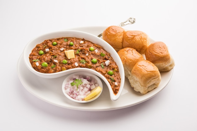 Mumbai Style Pav bhaji é um prato de fast food da Índia, que consiste em um curry de vegetais grosso servido com um pãozinho macio, servido em um prato