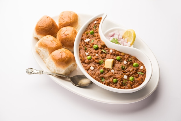 Mumbai Style Pav bhaji é um prato de fast food da Índia, que consiste em um curry de vegetais grosso servido com um pãozinho macio, servido em um prato