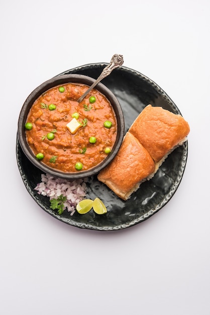 Mumbai Style Pav bhaji es un plato de comida rápida de la India, consiste en un curry de verduras espeso servido con un panecillo suave, servido en un plato