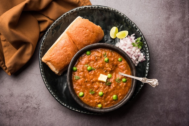 Mumbai Style Pav bhaji es un plato de comida rápida de la India, consiste en un curry de verduras espeso servido con un panecillo suave, servido en un plato