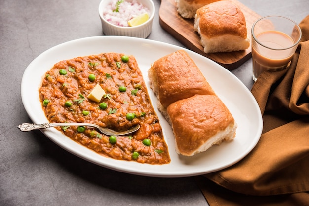 Mumbai Style Pav bhaji es un plato de comida rápida de la India, consiste en un curry de verduras espeso servido con un panecillo suave, servido en un plato