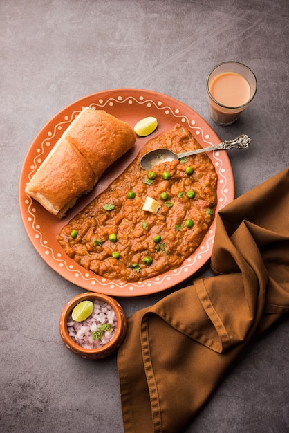 Mumbai Style Pav bhaji es un plato de comida rápida de la India, consiste en un curry de verduras espeso servido con un panecillo suave, servido en un plato