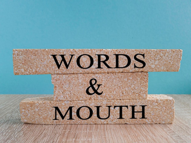Mundpropaganda-Symbol Konzeptwörter Mundpropaganda auf Ziegelblöcken auf einem schönen Holztisch