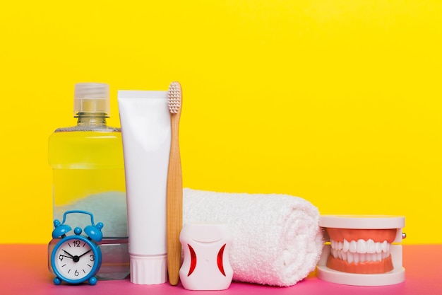 Mundwasser und andere Mundhygieneprodukte auf farbiger Tischplatte mit Kopierbereich Flach liegend Zahnhygiene Mundpflegeset Zahnarztkonzept