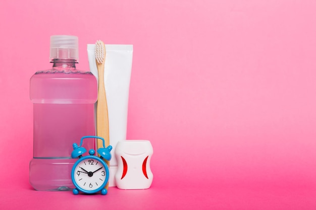 Mundwasser und andere Mundhygieneprodukte auf farbiger Tischplatte mit Kopierbereich Flache Lage Zahnhygiene Mundpflegeprodukte und Platz für Text auf hellem Hintergrundkonzept