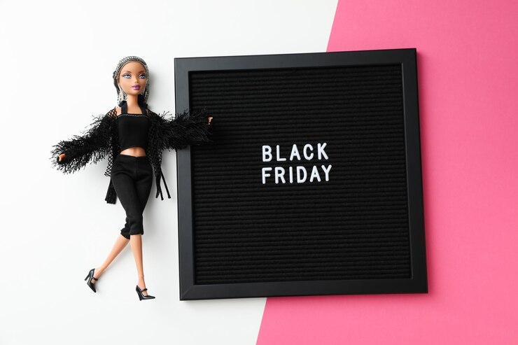 Muñeca adicta a las compras del concepto del Viernes Negro sobre un fondo rosa