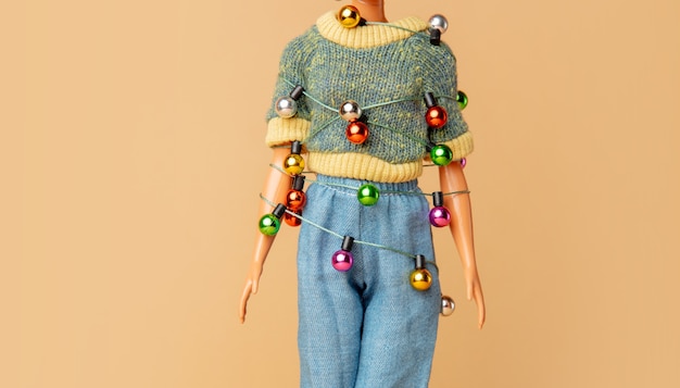 Muñeca femenina con luces de Navidad atadas