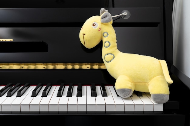 Foto muñeca jirafa amarilla en piano