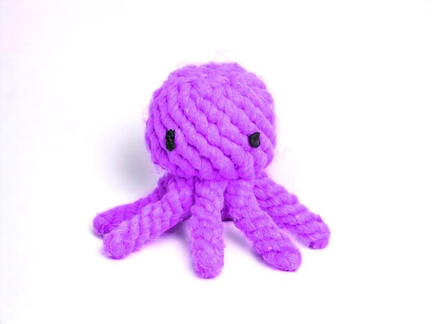 Muñeca de pulpo púrpura de cuerda tejida sobre un fondo blanco.