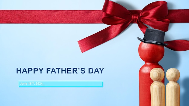 Foto muñecas de madera estatuilla de padre e hijos con arco rojo en un fondo azul feliz idea de día del padre