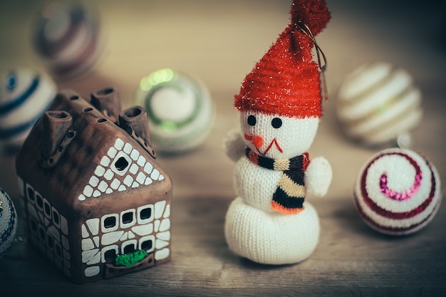 Muñeco de nieve de juguete y casa de pan de jengibre en la mesa de Navidad .foto con espacio de copia.