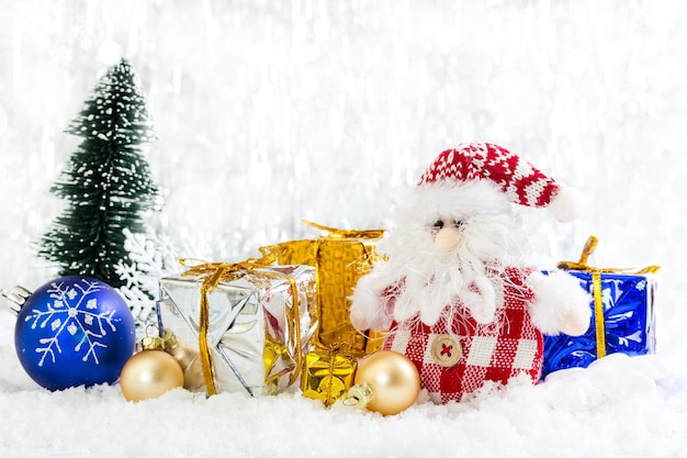 Muñeco de nieve de juguete de Navidad con regalos sobre fondo nevado