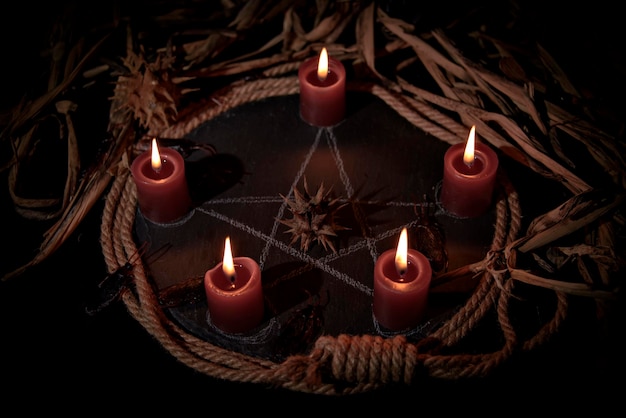 Muñeco vudú velas negras pentagrama y libros antiguos sobre mesa de brujas Adivinación esotérica oculta y concepto de wicca Vudú místico y fondo vintage