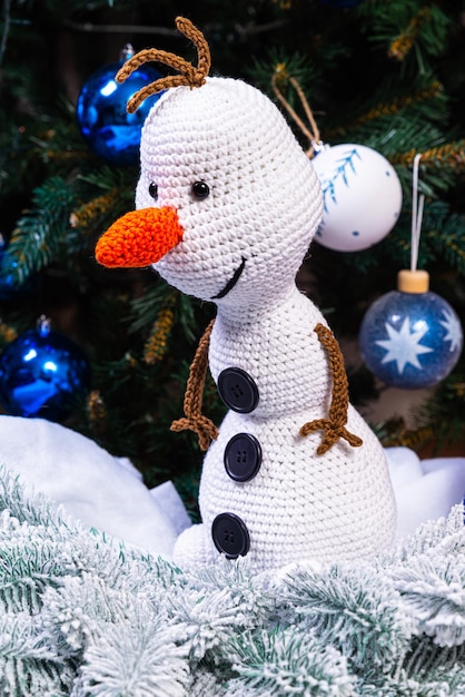 Foto muñecos de nieve tejidos con coloridos sombreros y bufandas sobre un fondo azul el concepto de navidad año nuevo y cuento de hadas de invierno