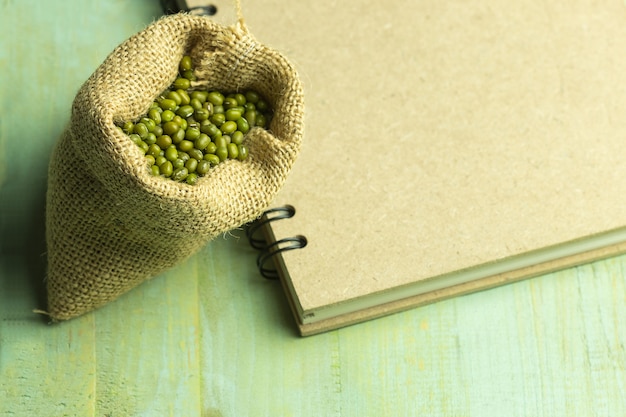 Mungobohne auf Sack mit braunem Buch