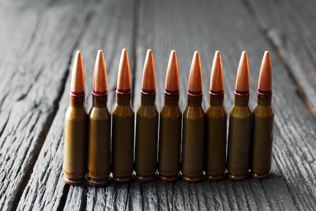 Munitionsgeschosse scharfe Munition für Schusswaffen auf schwarzem Holzhintergrund