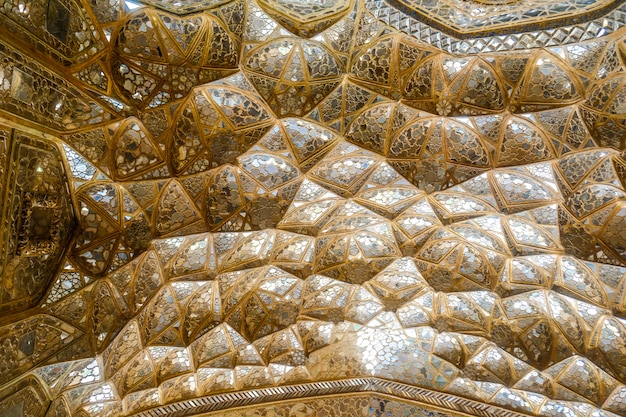 Foto muqarnas de ouro saltando com o trabalho de espelho no palácio chehel sotoun. isfahan, irã.