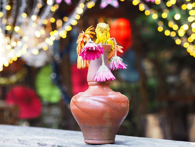 Murcha Gerbera flor em um vaso marrom na mesa de madeira