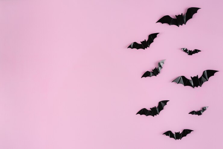 Murciélagos de papel negro volando sobre rosa