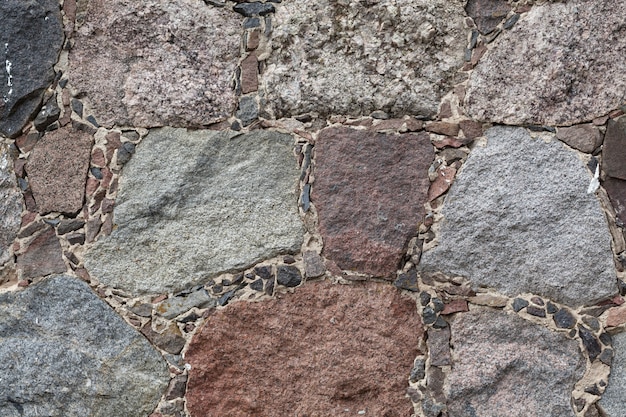 Muro del castillo medieval con piedras y ladrillos rojos