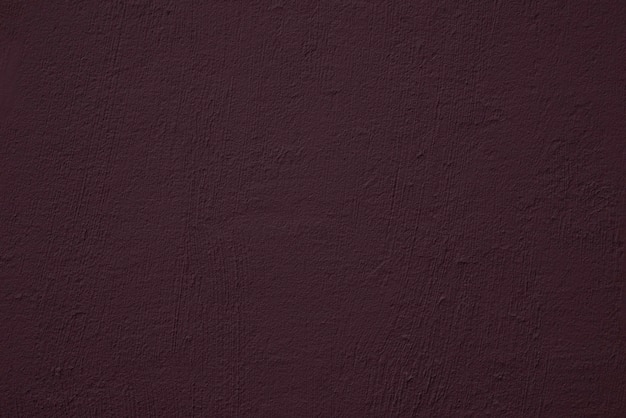 Muro de cemento morado oscuro con textura rústica. Telón de fondo de hormigón.