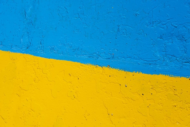 Muro de cemento pintado en amarillo y azul como bandera ucraniana el país de la víctima del agresor