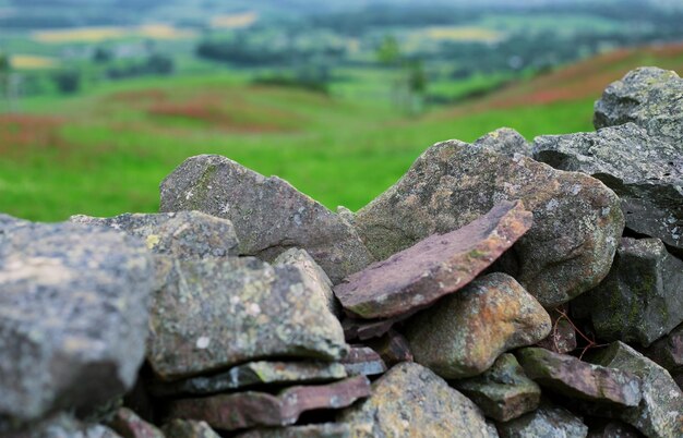 Muro de pedra seco contra colinas verdes