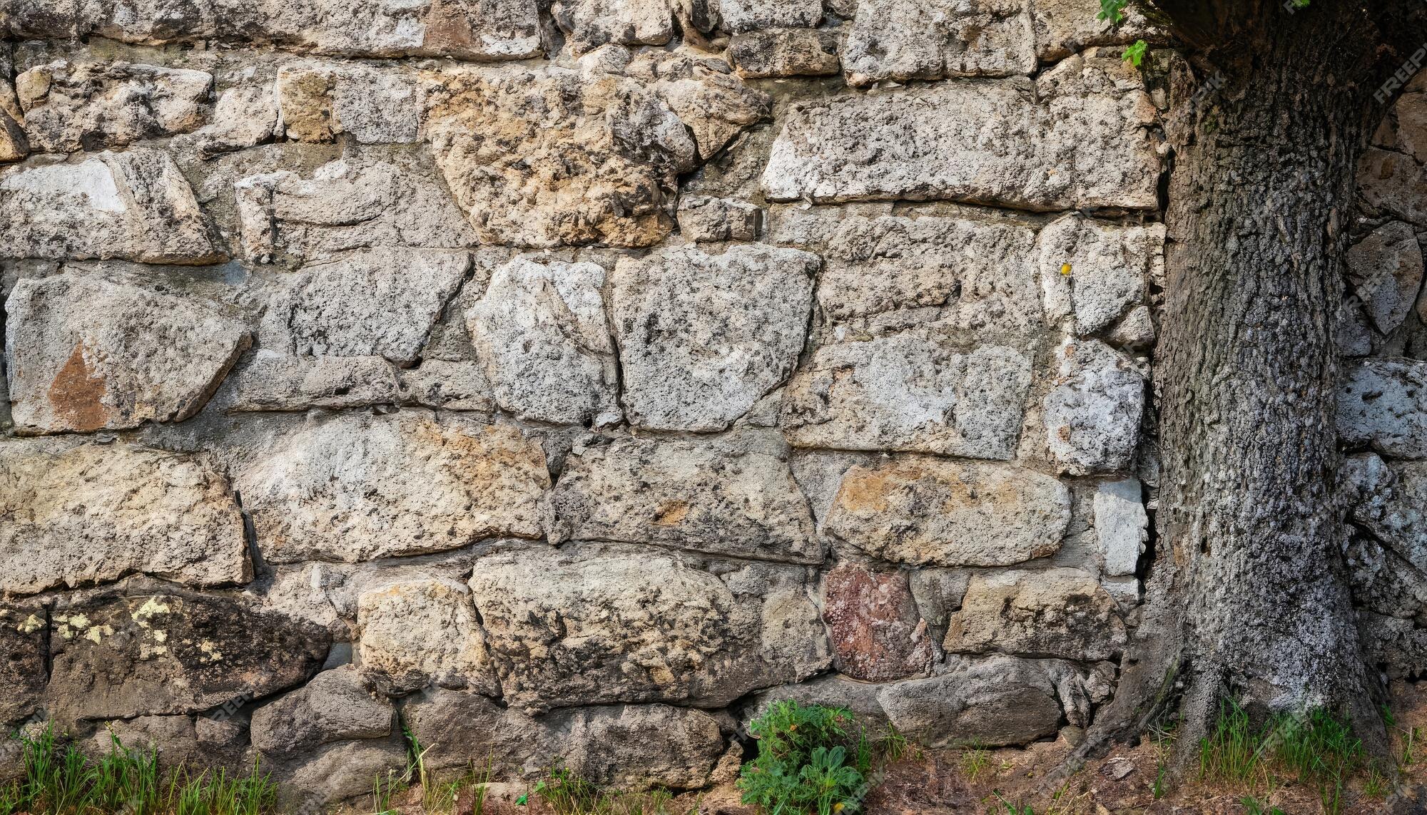 Velho muro de pedra feito de várias pedras naturais quadradas em