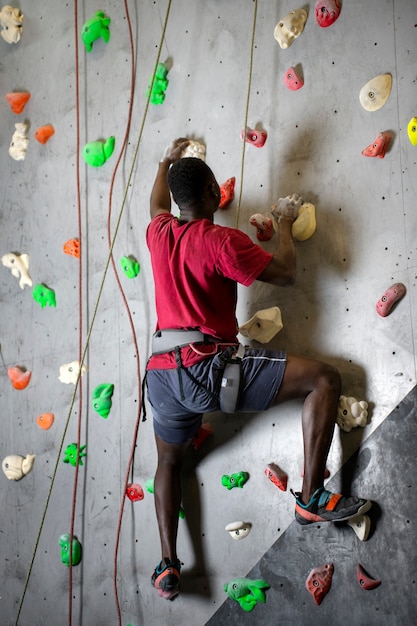 Foto muro de escalada de hombre de tiro completo