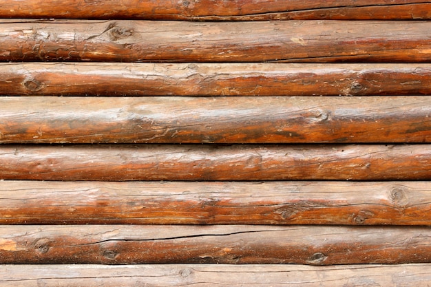 Muro hecho de troncos de madera. textura de la cerca de vigas de madera