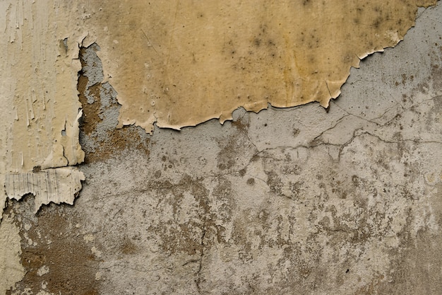 Muro de hormigón agrietado cubierto con superficie de cemento dorado como fondo