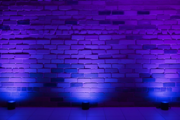 Un muro de ladrillo púrpura con tres luces azules