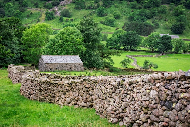 Muro de piedra y una casa en el Distrito de los Lagos de Inglaterra