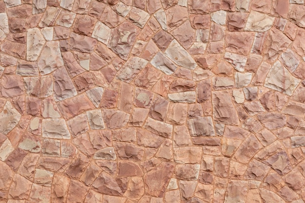 Muro de piedra decorativa en tonos rosados de fondo