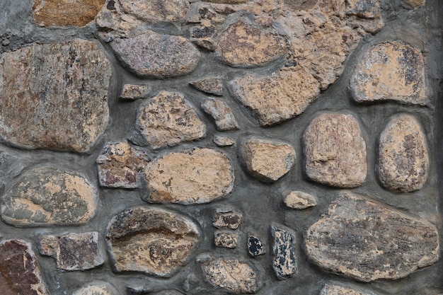 Muro de piedra gris oscuro superficie de roca desigual azulejo vintage decorativo del edificio de fachada desgastada