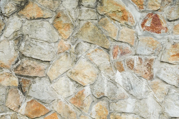 Un muro de piedra con un letrero blanco