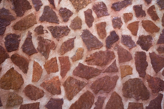 Muro de piedra de mampostería con calizas rojas.