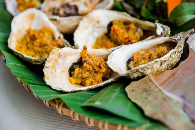 Muscheln auf der Schüssel mit dem Palmblatt.