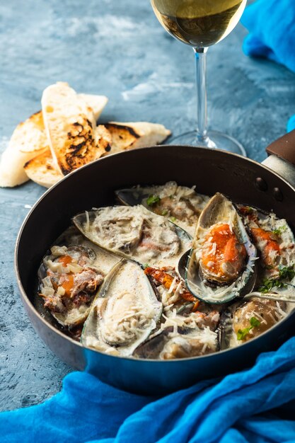 Muscheln mit Blauschimmelkäsesauce und Knoblauchbaguette.