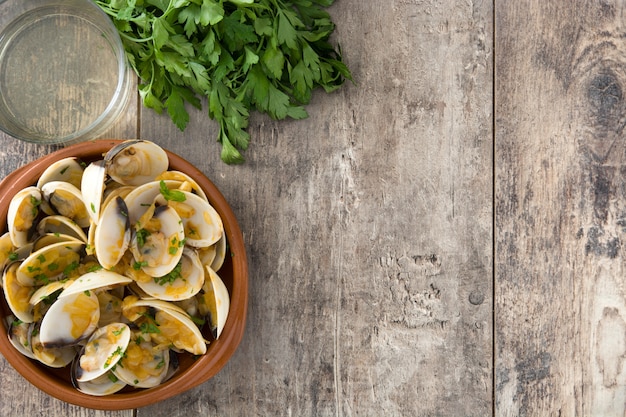Muscheln mit Marinerasoße Spanisches Rezept Almejas a la Marinera auf hölzerner Tabelle