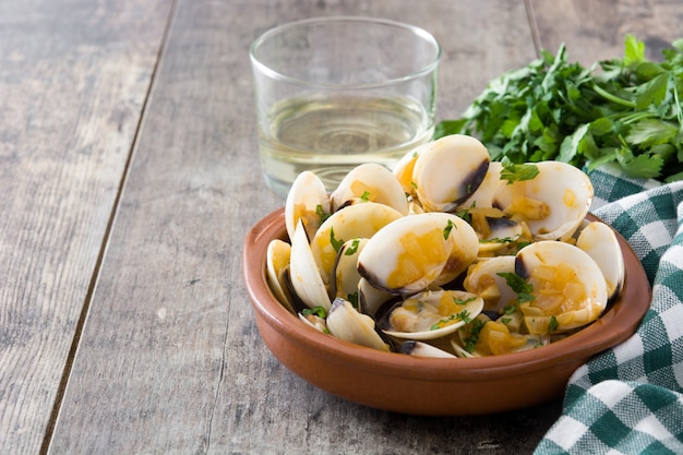 Muscheln mit Marinerasoße Spanisches Rezept Almejas a la Marinera auf Holztisch