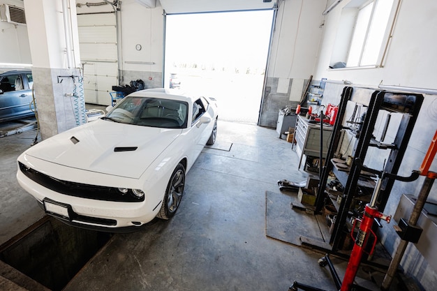 Muscle car en el hoyo en la estación de reparación de servicio