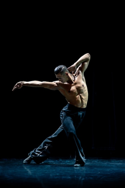 Muscular Ballroom Tänzer oben ohne machen Pose isoliert auf schwarzem Hintergrund.