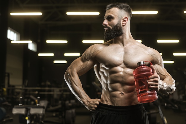 Músculos atléticos fuertes y guapos hombres beben agua y nutrición deportiva entrenamiento concepto de culturismo