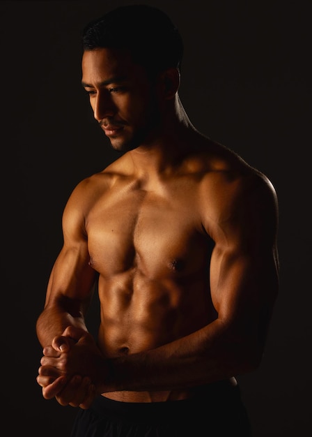 Los músculos duros hacen la mejor ropa Foto de estudio de un joven en forma posando sobre un fondo negro